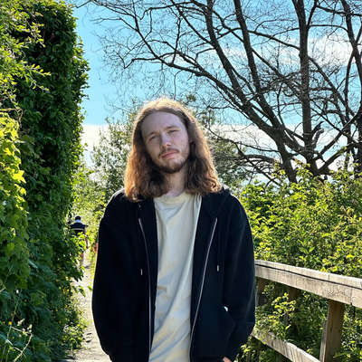 Ethan Plant standing on a wooden boardwalk surrounded by greenery.